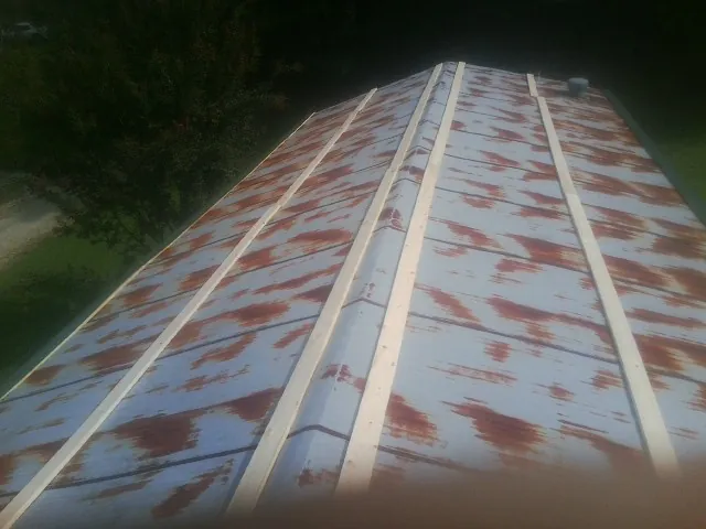 Rusted metal roof panels with new wood purlins before replacement — Storm Damage Roof Repair in Curtis by Roofing Brothers
