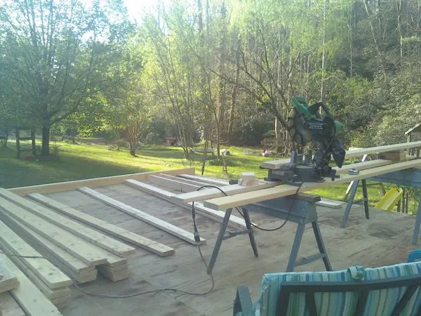Miter saw and framing lumber on a deck under construction in Curtis